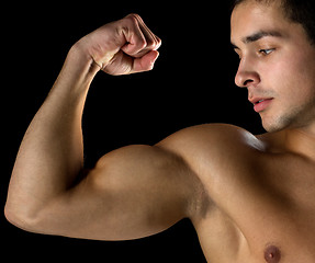 Image showing close up of young man showing biceps