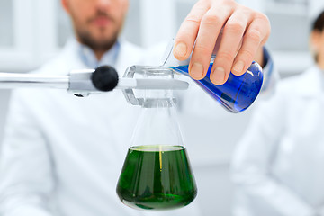 Image showing close up of scientist filling test tubes in lab