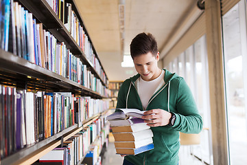 Image showing happy student or man with book in library