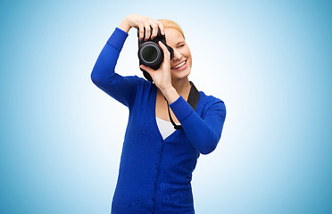 Image showing smiling woman taking picture with digital camera