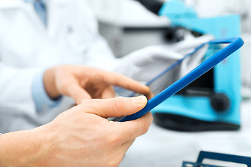 Image showing close up of scientists hands with tablet pc in lab