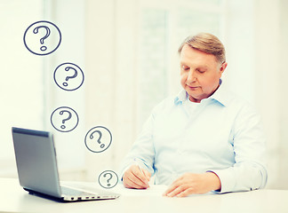 Image showing old man filling a form at home