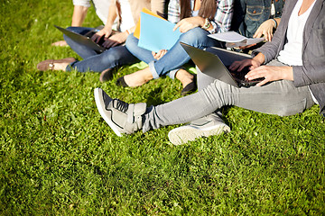 Image showing close up of students with laptop sitting on grass