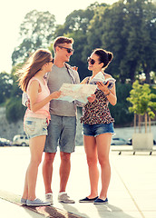 Image showing smiling friends with map and city guide outdoors