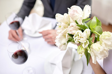 Image showing close up of couple with flowers at restaurant