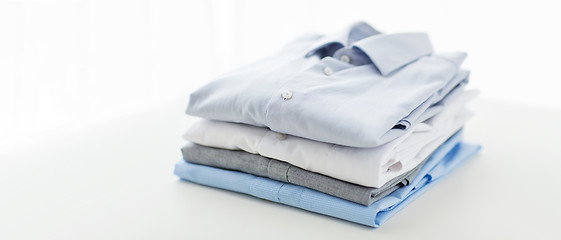 Image showing close up of ironed and folded shirts on table