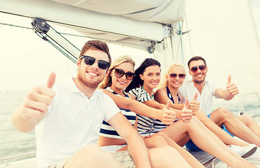 Image showing smiling friends on yacht showing thumbs up