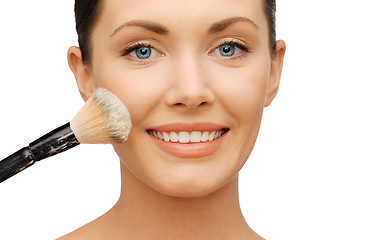 Image showing woman applying powder foundation with brush