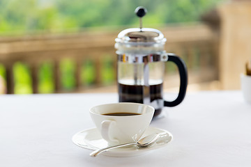 Image showing cup of coffee and french press on table 