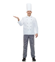 Image showing happy male chef cook showing empty palm