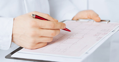 Image showing male doctor hands holding cardiogram