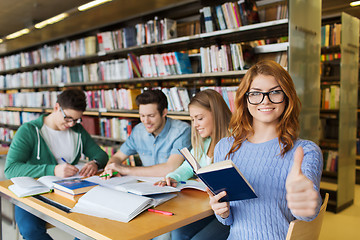 Image showing happy student girl showing thumbs up in library