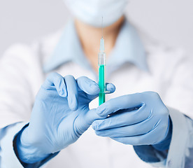 Image showing female doctor holding syringe with injection