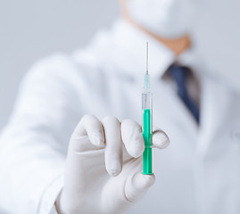 Image showing male doctor holding syringe with injection