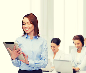 Image showing smiling woman looking at tablet pc at office