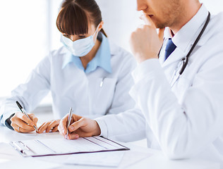 Image showing doctor and nurse writing prescription paper