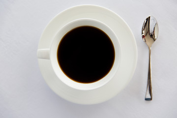 Image showing cup of black coffee with spoon and saucer on table