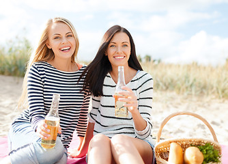 Image showing happy young women drinking beer on beach