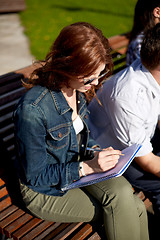 Image showing student girl writing to notebook at campus