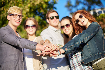 Image showing close up of teenage friends with hands on top