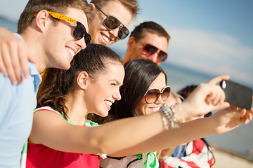 Image showing group of friends taking selfie with cell phone