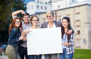 Image showing happy teenage students holding white blank board