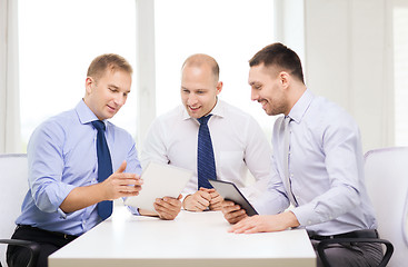 Image showing three smiling businessmen with tablet pc in office