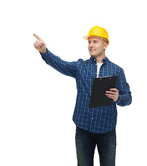 Image showing smiling man in helmet with clipboard