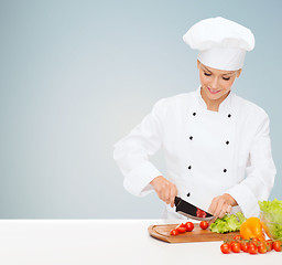 Image showing smiling female chef chopping vegetables