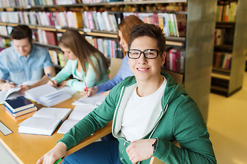 Image showing happy student boy reading books in library