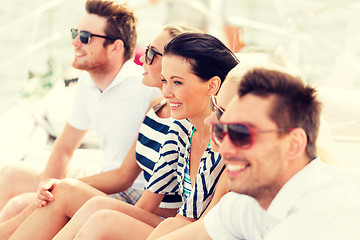 Image showing smiling friends sitting on yacht deck