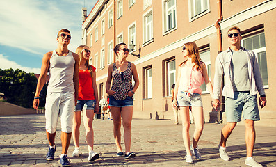 Image showing group of smiling friends walking in the city