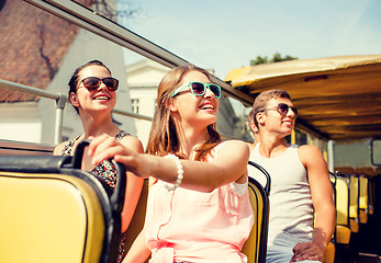 Image showing group of smiling friends traveling by tour bus