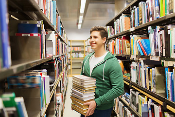 Image showing happy student or man with book in library