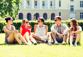 Image showing group of smiling friends outdoors sitting on grass