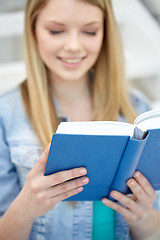 Image showing close up of young woman reading book at school