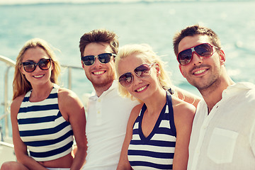 Image showing smiling friends sitting on yacht deck