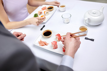 Image showing close up of couple eating sushi at restaurant