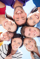 Image showing smiling friends in circle on summer beach