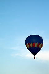 Image showing mostly blue hot air balloon flying in sky
