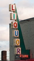 Image showing Vertical Liquor Store Sign Brick Wall Outside Advetisement