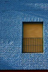 Image showing old yellow window in light blue wall 