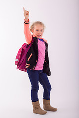 Image showing Blond small girl with school bag on the back, points with the finger in the air