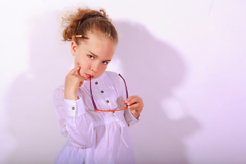 Image showing Blond girl with ear piece in the mouth