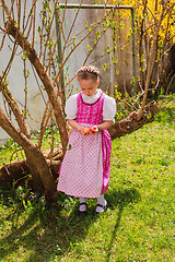 Image showing Girl in the dirndl is bored with coloured ones wobble in the hand