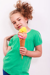 Image showing Young blond wavy girl with ice-cream cone in the hand