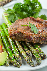 Image showing Glazed green asparagus with grilled pork chop