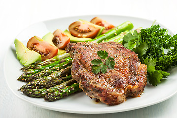 Image showing Glazed green asparagus with grilled pork chop