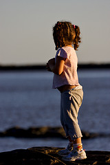 Image showing little girl in the sunrise near the  beach