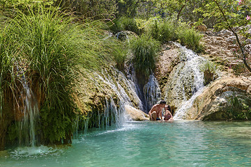 Image showing Couple hugging and kissing under waterfall